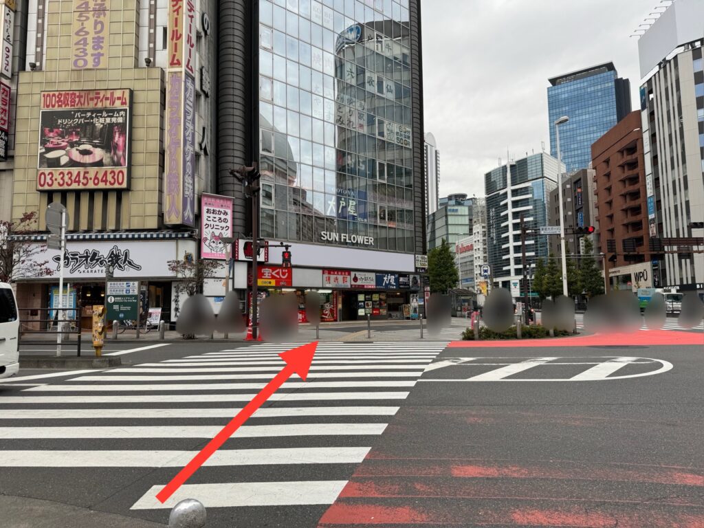 新宿サンフラワービル方面に横断歩道を渡る。